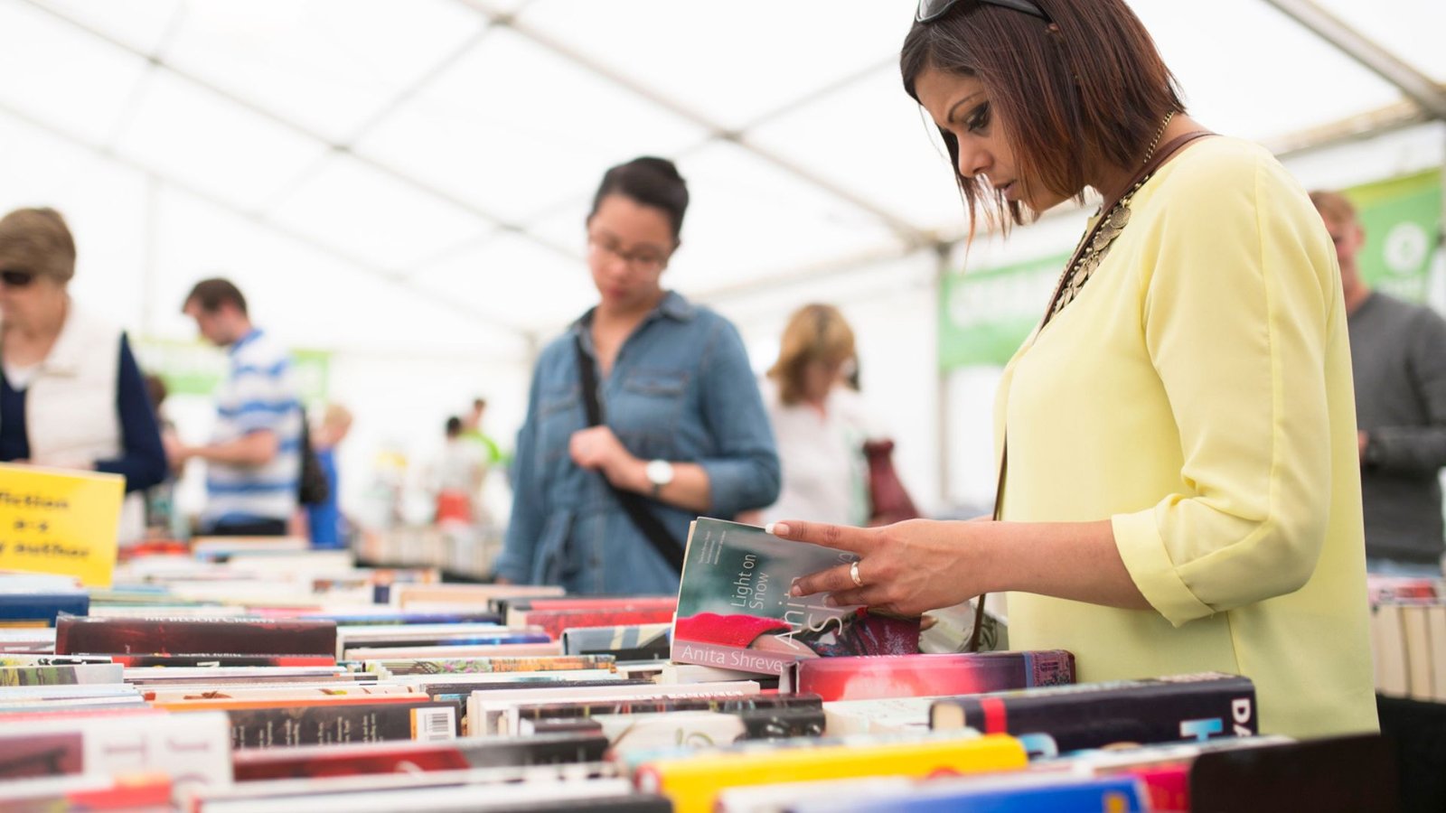 People looking at books showing how Literary Festivals Spark Creativity.